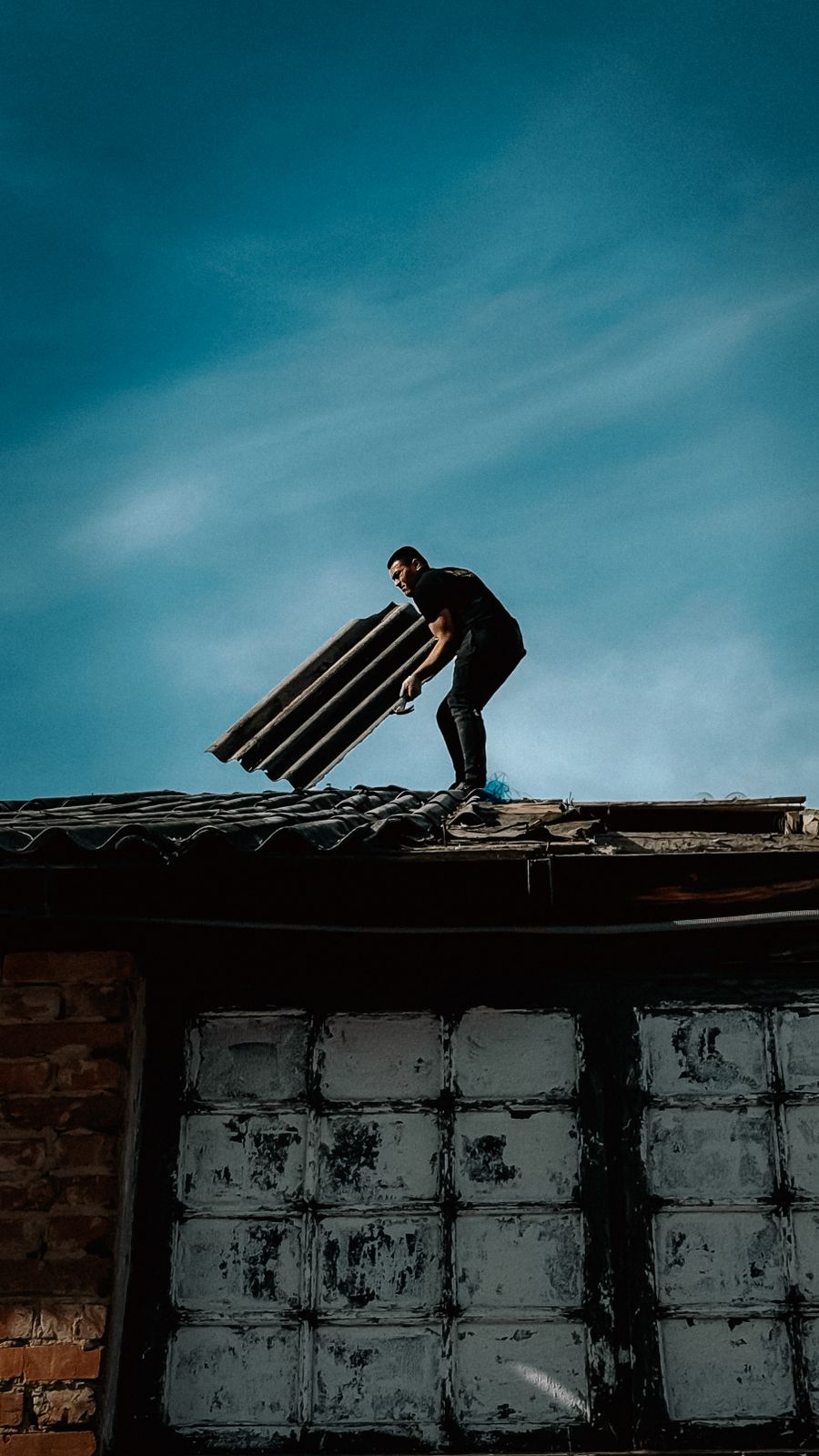 Roofer inspecting a roof, related to blog article on roof lifespan